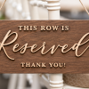 Close-up of rustic wood reserved row wedding chair sign