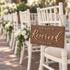 Rustic reserved wedding sign hanging on a white ceremony chair