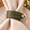 Olivia napkin ring with brushed silver button OD Green faux leather napkin ring engraved with Olivia and finished with a silver button on a white napkin