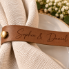 Sophia & Daniel Wedding Napkin Ring Long brown faux leather napkin ring engraved with Sophia & Daniel on a white wedding napkin